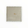Rectangular ceramic tray with a textured surface and gold emblem on a white background