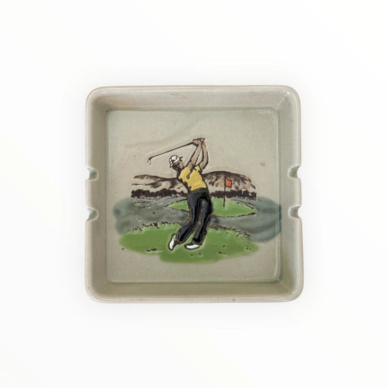 Ceramic tray with a golf-themed design on a white background