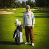 Pedro wearing the Play Your Best Structured Snapback Hat (Khaki/Green) and Bar Logo Hoodie (Grey) with Pin Stripes Golf Headcovers on his golf bag